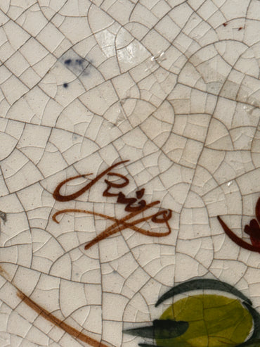 Close-up of a ceramic surface with a signature.